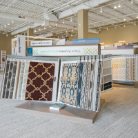 Patterned carpet samples with geometric and damask designs in the showroom.